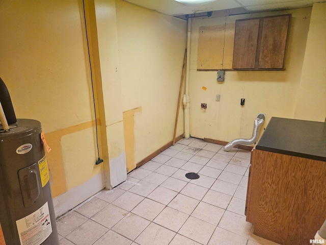 laundry room with cabinets, hookup for an electric dryer, water heater, and light tile patterned floors