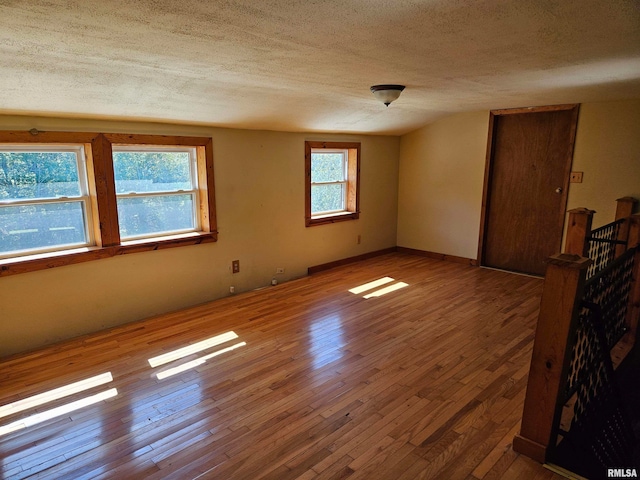 spare room with wood-type flooring and a textured ceiling