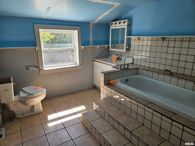 bathroom featuring vaulted ceiling, tile patterned flooring, toilet, and a tub