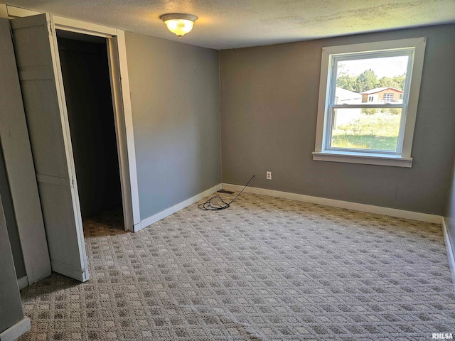 unfurnished room featuring a textured ceiling and carpet flooring