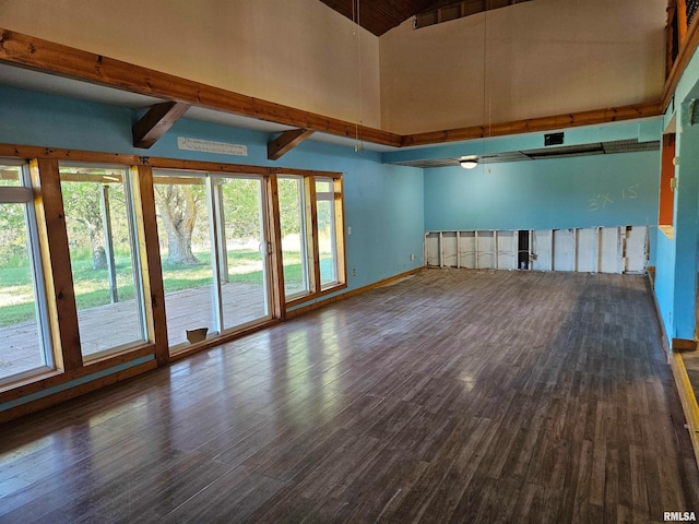 spare room with high vaulted ceiling, beam ceiling, and dark hardwood / wood-style flooring