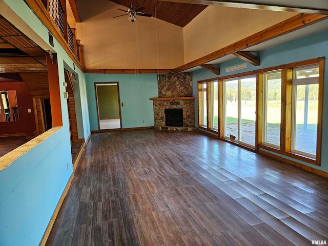 unfurnished living room with dark hardwood / wood-style flooring, beamed ceiling, high vaulted ceiling, a stone fireplace, and ceiling fan