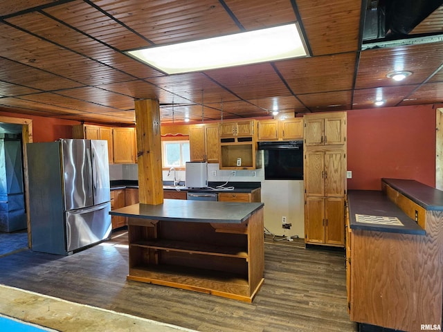 kitchen featuring appliances with stainless steel finishes, sink, a kitchen island, and dark hardwood / wood-style flooring