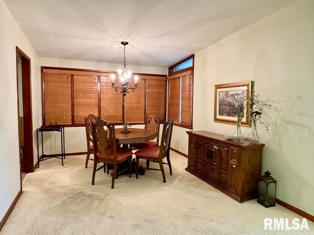 dining area with a chandelier, baseboards, and light colored carpet