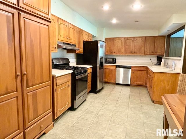 kitchen featuring appliances with stainless steel finishes, decorative backsplash, and light tile patterned floors