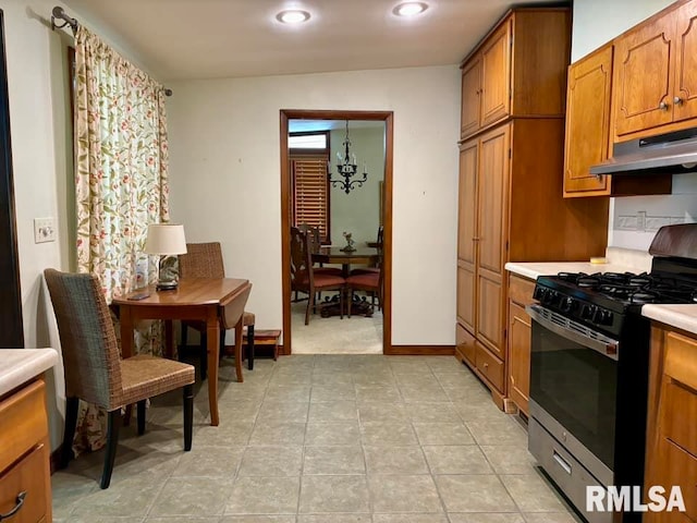 kitchen with a notable chandelier, stainless steel gas stove, and light tile patterned floors