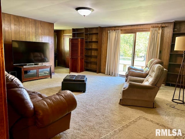 living area with light carpet and wood walls