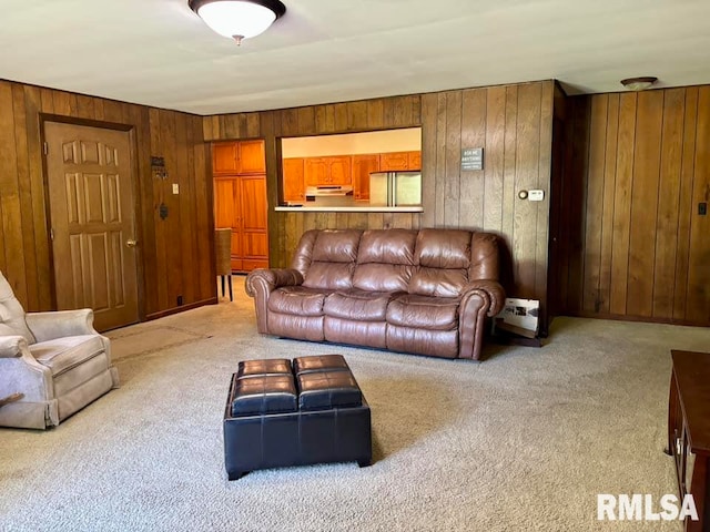 living room featuring wooden walls and light colored carpet