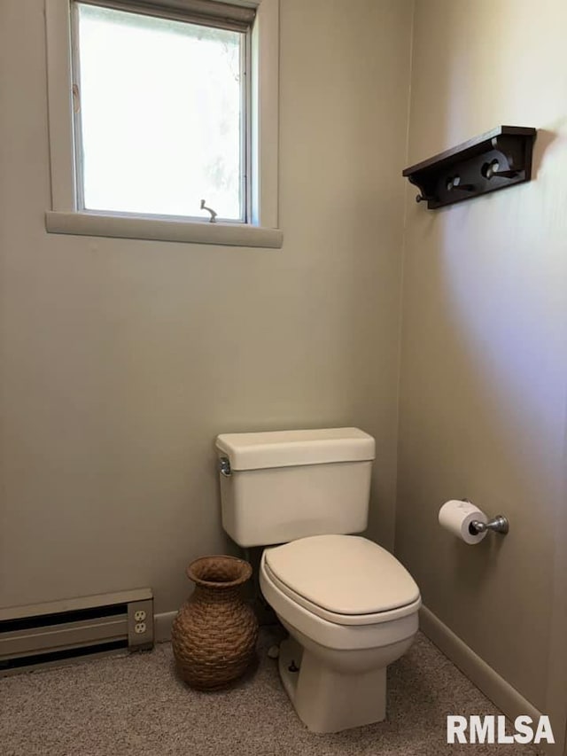 bathroom with baseboard heating, toilet, and baseboards