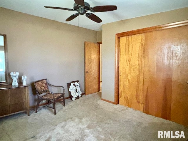 living area with ceiling fan and light colored carpet