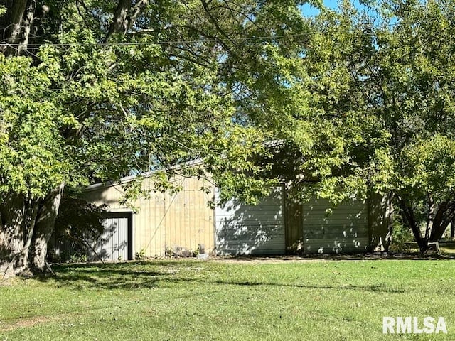 view of yard with a garage and an outbuilding