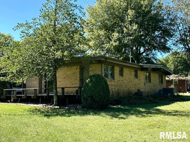 view of side of home with a yard and central air condition unit