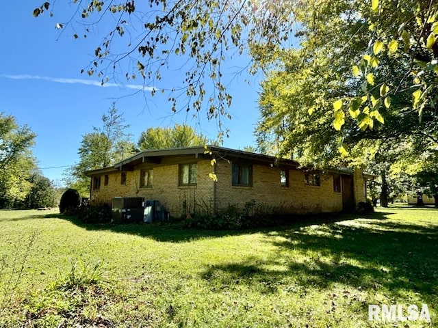 view of side of property with a yard and brick siding