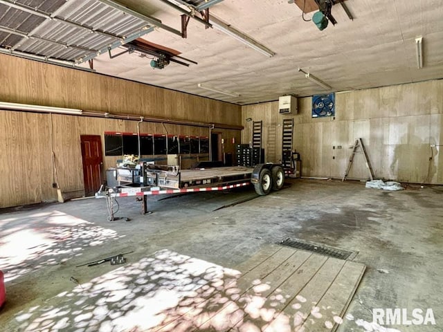 garage with a garage door opener and wooden walls