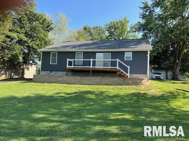 rear view of property with a deck and a lawn