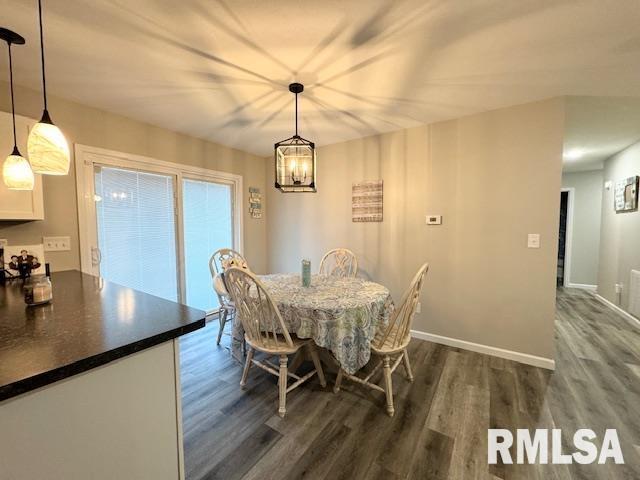 dining space featuring dark hardwood / wood-style flooring and a notable chandelier