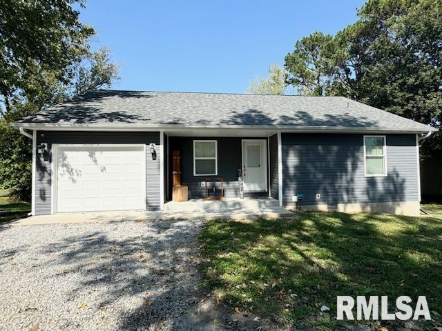 ranch-style home with a front yard, covered porch, and a garage