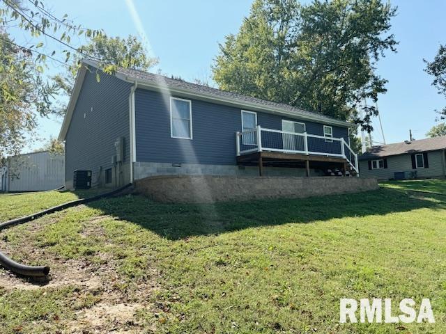 back of house featuring central AC unit and a yard