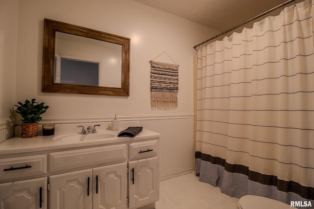 bathroom featuring vanity, curtained shower, and toilet