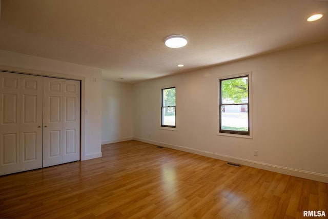 unfurnished bedroom with a closet and light wood-type flooring