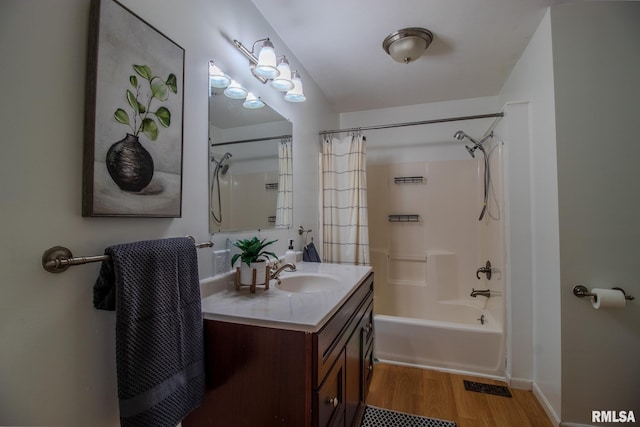 bathroom featuring hardwood / wood-style floors, vanity, and shower / bath combo