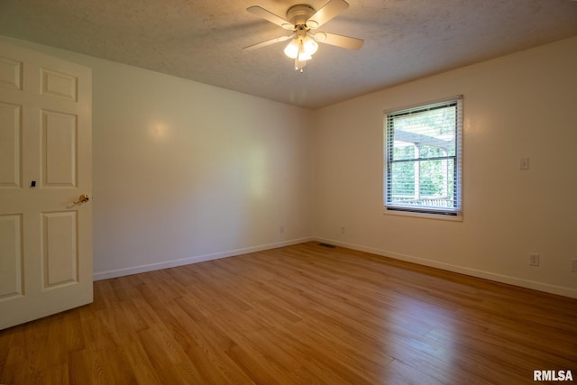 unfurnished room featuring ceiling fan, light hardwood / wood-style floors, and a textured ceiling