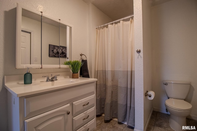 bathroom with tile patterned flooring, vanity, and toilet