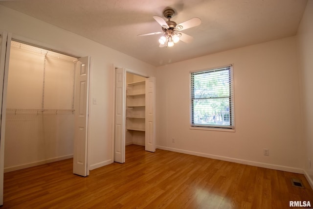 unfurnished bedroom with ceiling fan and light wood-type flooring