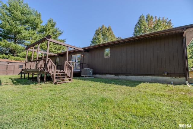 back of house with a lawn, a wooden deck, cooling unit, and a storage shed