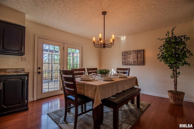 dining space featuring a chandelier, a textured ceiling, and dark hardwood / wood-style flooring