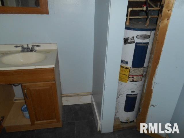 bathroom with electric water heater, vanity, and tile patterned floors