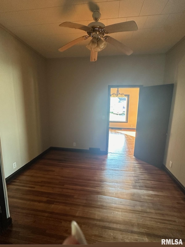 empty room with dark hardwood / wood-style flooring and ceiling fan