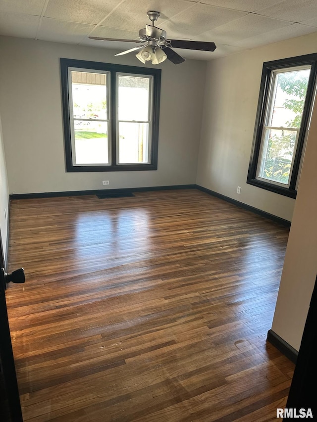 spare room featuring ceiling fan, dark hardwood / wood-style floors, and a paneled ceiling