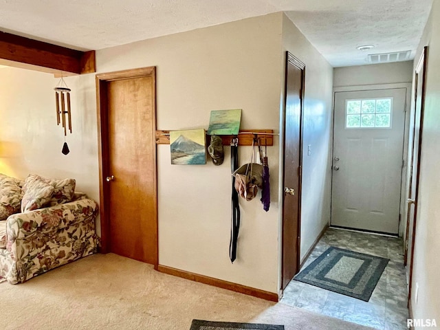 doorway to outside with light carpet and a textured ceiling