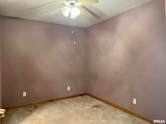 spare room featuring a textured ceiling, carpet flooring, and ceiling fan