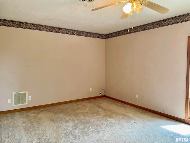 spare room featuring a textured ceiling, ceiling fan, and light colored carpet