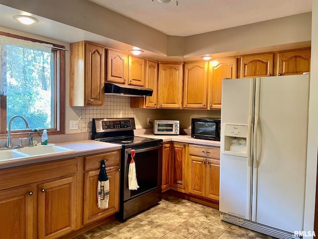 kitchen with white fridge with ice dispenser, sink, backsplash, and stainless steel range with electric cooktop