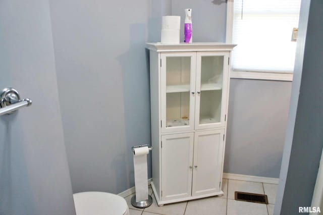 bathroom with toilet and tile patterned floors