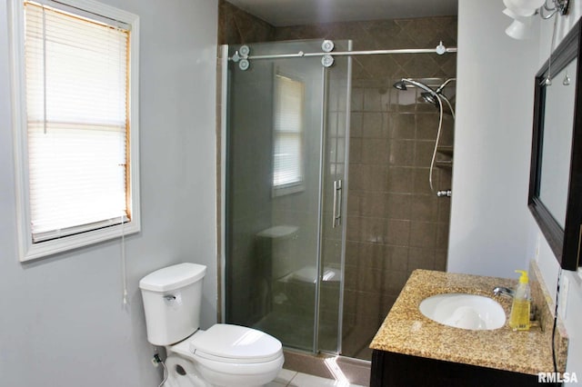 bathroom featuring vanity, toilet, and a shower with door