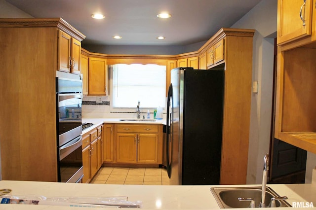 kitchen featuring light tile patterned floors, appliances with stainless steel finishes, sink, and tasteful backsplash