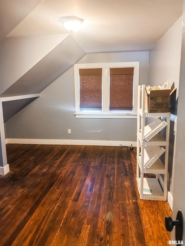 additional living space featuring lofted ceiling and dark hardwood / wood-style flooring