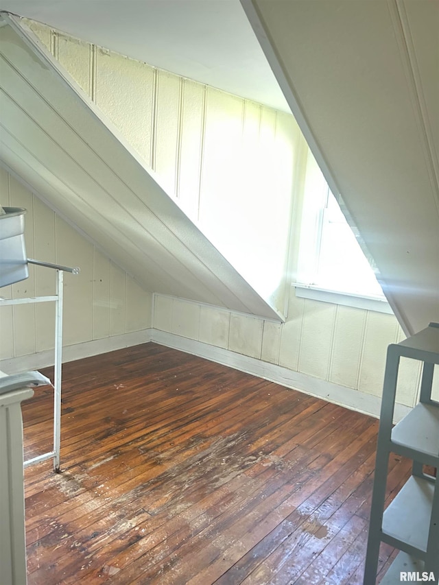 bonus room with lofted ceiling and dark hardwood / wood-style flooring