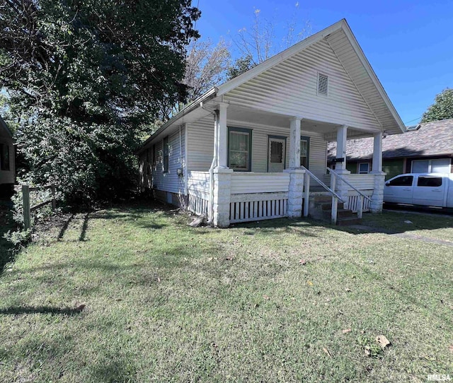 bungalow-style home with a front yard and covered porch