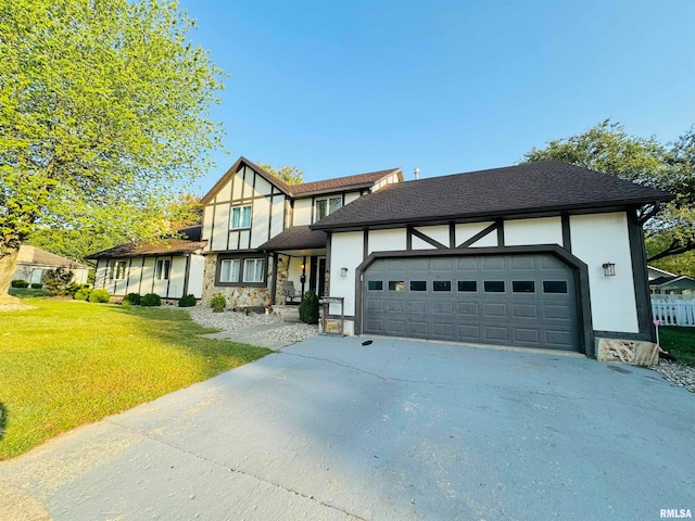 english style home featuring a front lawn and a garage