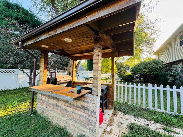 view of patio featuring grilling area, an outdoor kitchen, and exterior bar