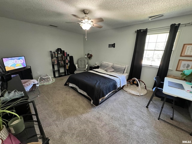 carpeted bedroom featuring a textured ceiling and ceiling fan