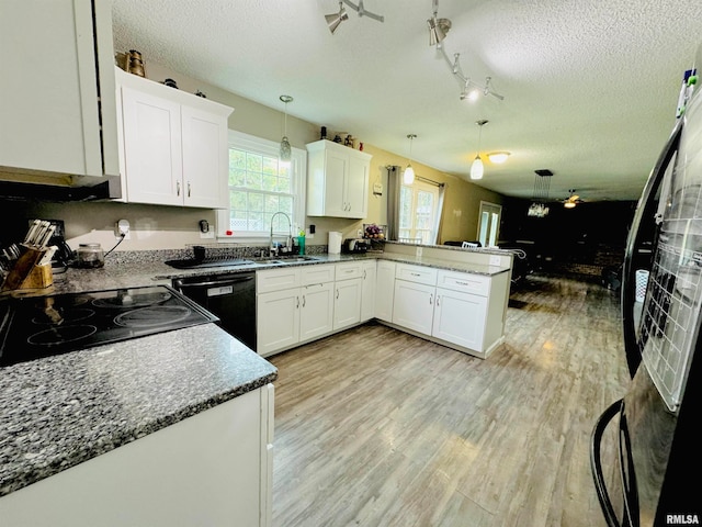 kitchen featuring white cabinets, hanging light fixtures, sink, kitchen peninsula, and black appliances