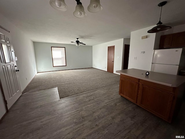 kitchen featuring ceiling fan, white refrigerator, and dark hardwood / wood-style flooring