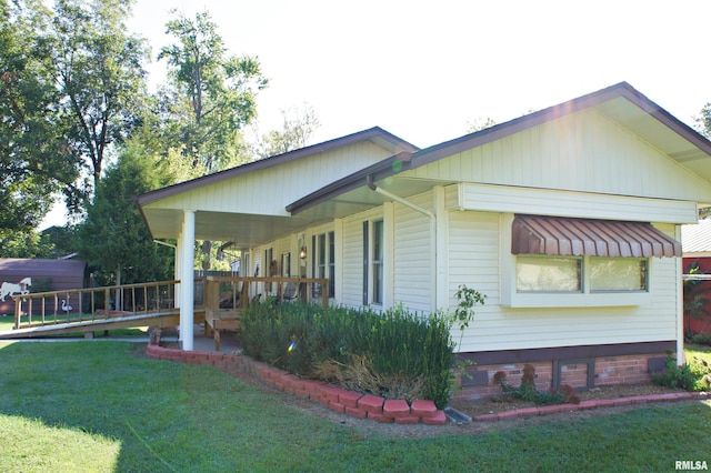 view of side of home with a yard