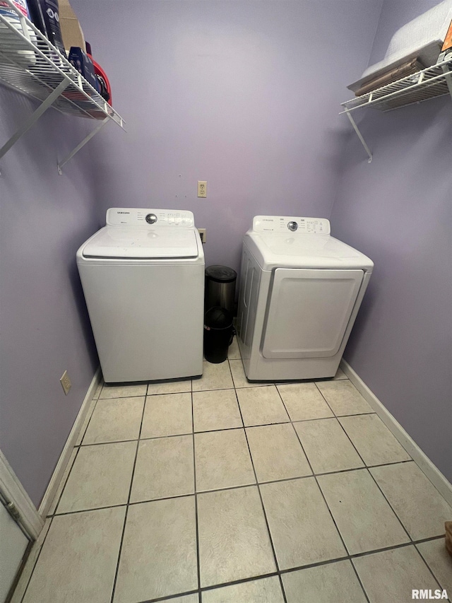 clothes washing area featuring light tile patterned flooring and independent washer and dryer